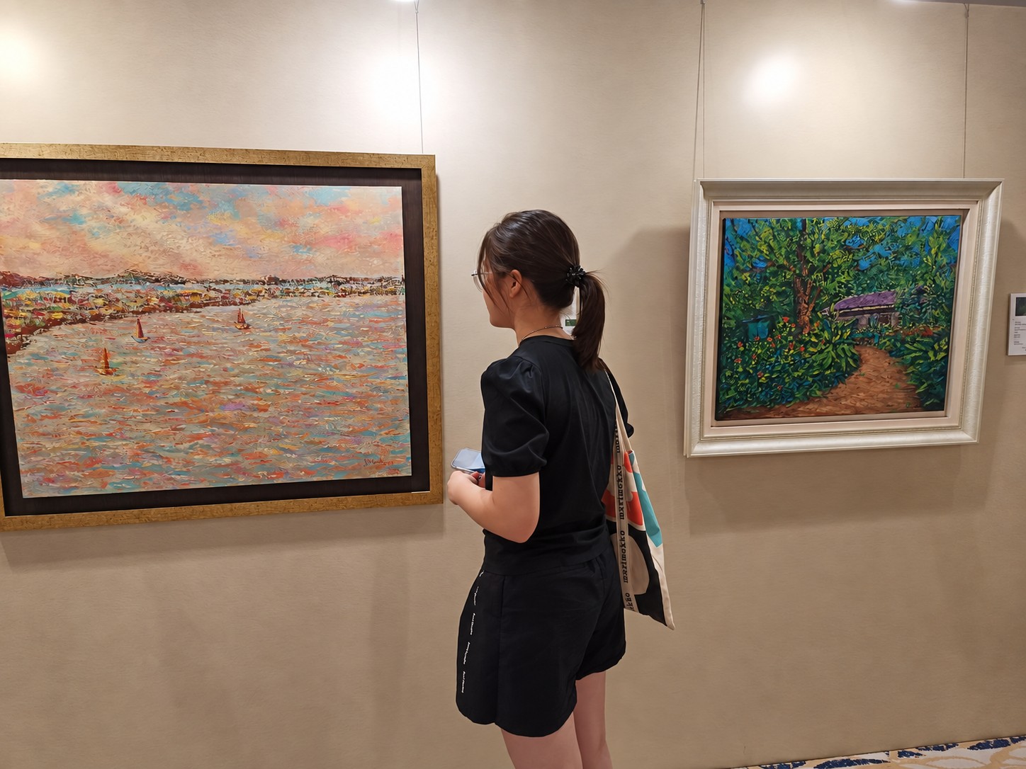 学生在画展现场观察作品